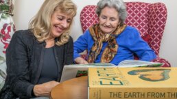 Care Home Norwich Resident and Carer enjoying a book together at Redlands House Care Home