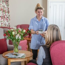 Residential Care Home Norwich, Carer serving a resident tea